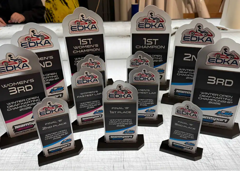 A collection of EDKA kart racing trophies for various categories, including 1st, 2nd, and 3rd place, women's champion, and fastest lap, all labelled for the Winter Open Championship 2025.